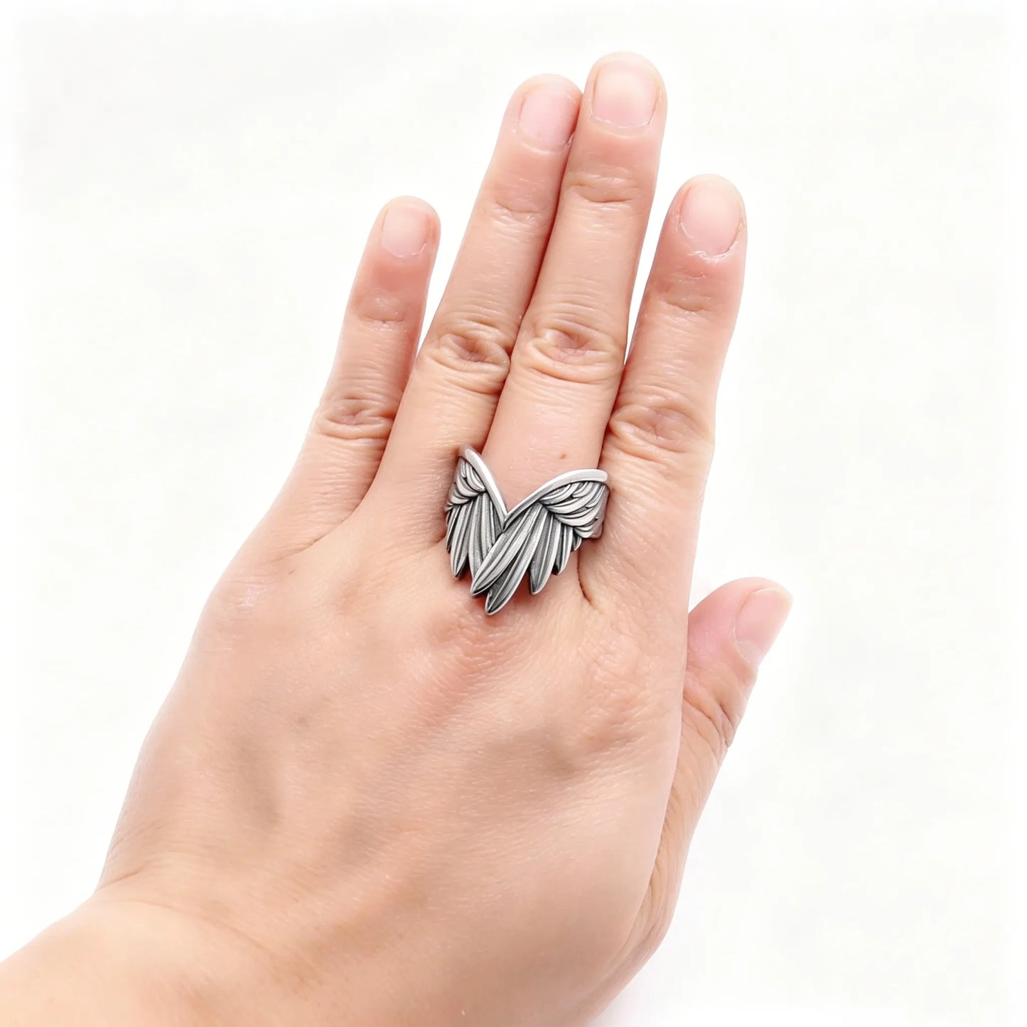 Adjustable stainless steel angel feather ring worn on a finger with vintage silver finish