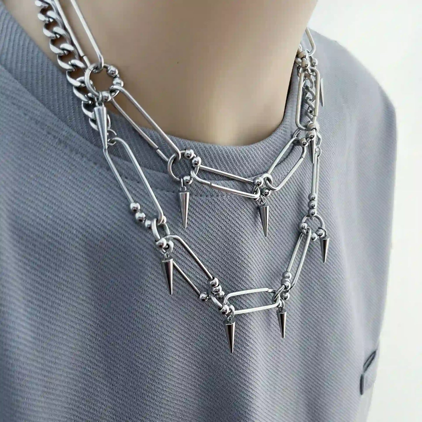 Silver-tone stainless steel punk choker necklace featuring elongated links and cone spike details.