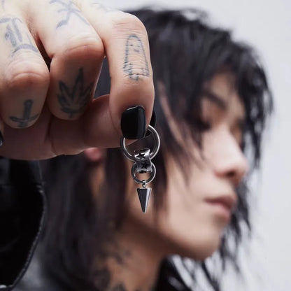 Close-up of a model wearing an edgy stainless steel star and spike dangle hoop earring