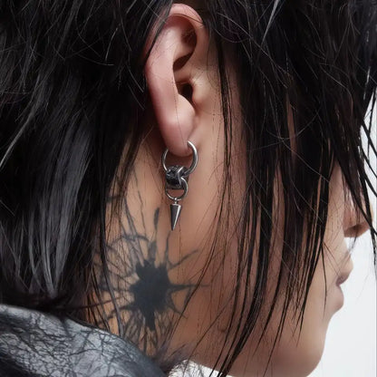 Close-up of a model wearing an edgy stainless steel star and spike dangle hoop earring