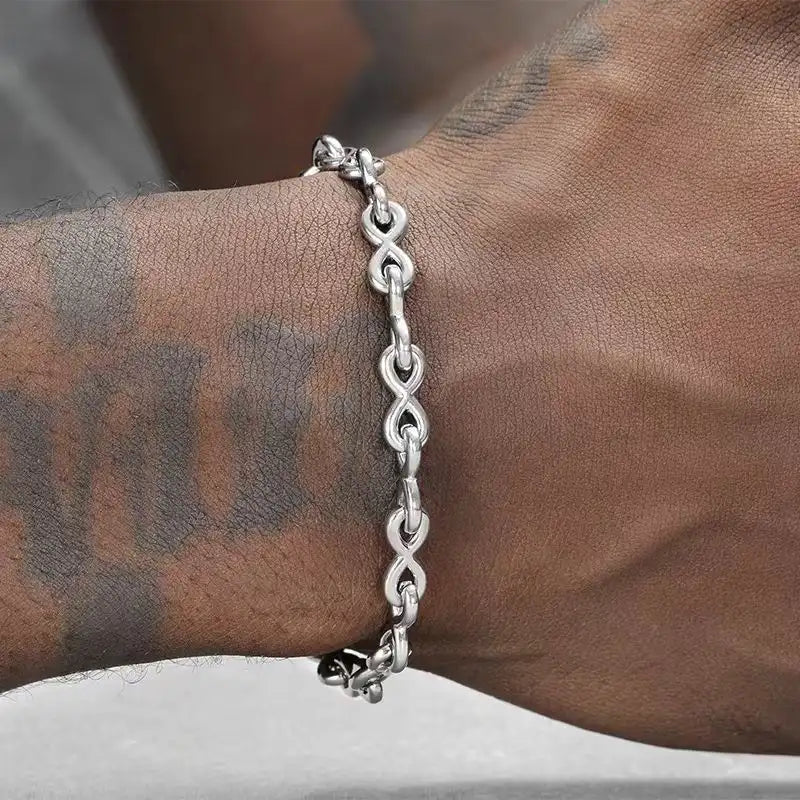 Person wearing a minimalist infinity link stainless steel bracelet on the wrist.