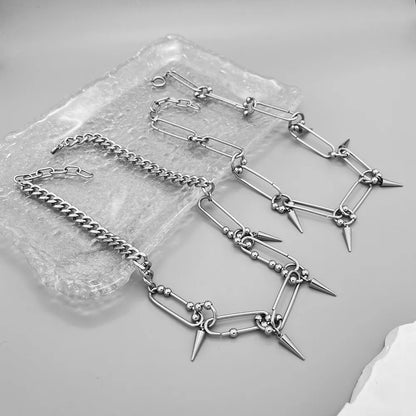 Stainless steel spike link chain choker necklace with polished silver finish and hanging spike accents.