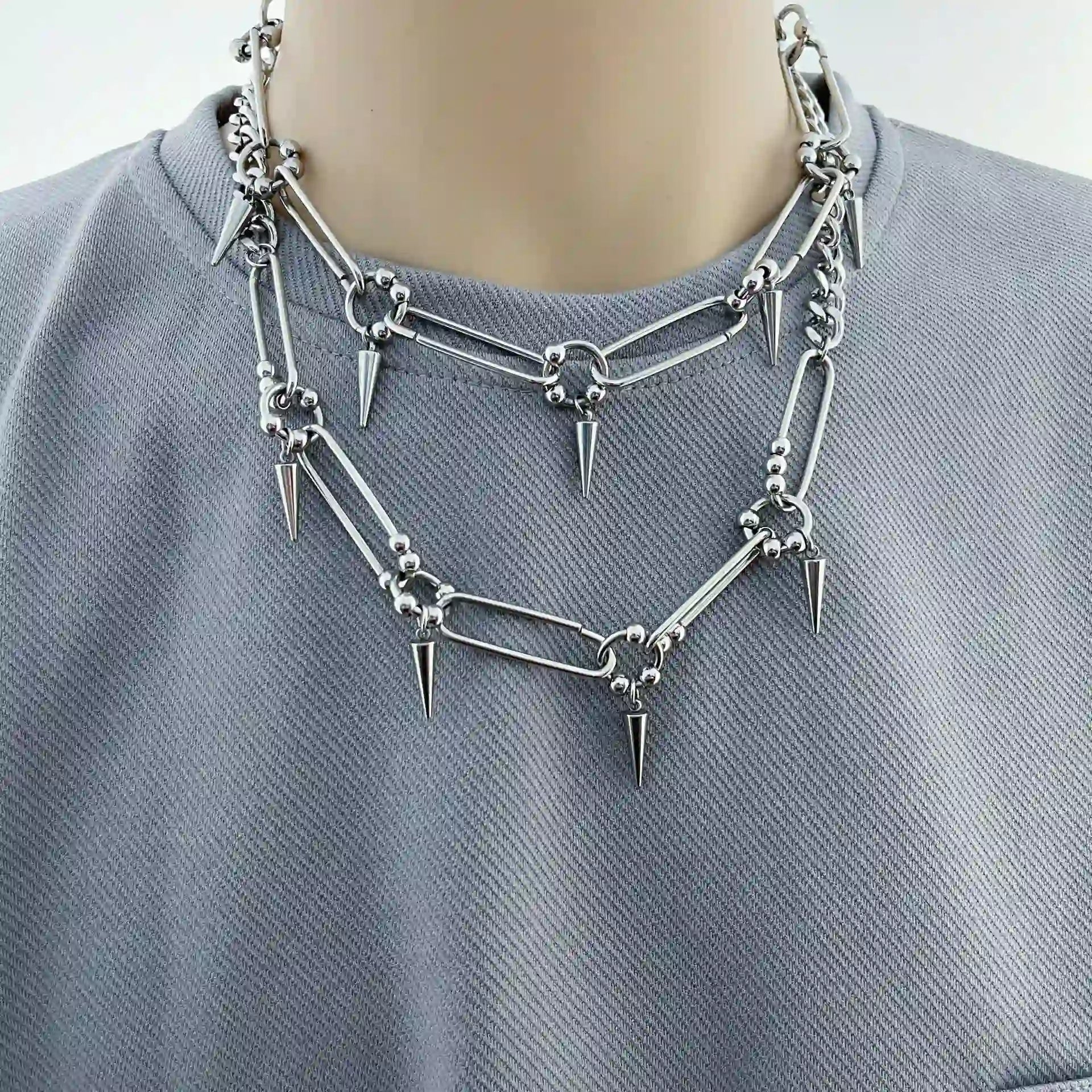 Silver-tone stainless steel punk choker necklace featuring elongated links and cone spike details.