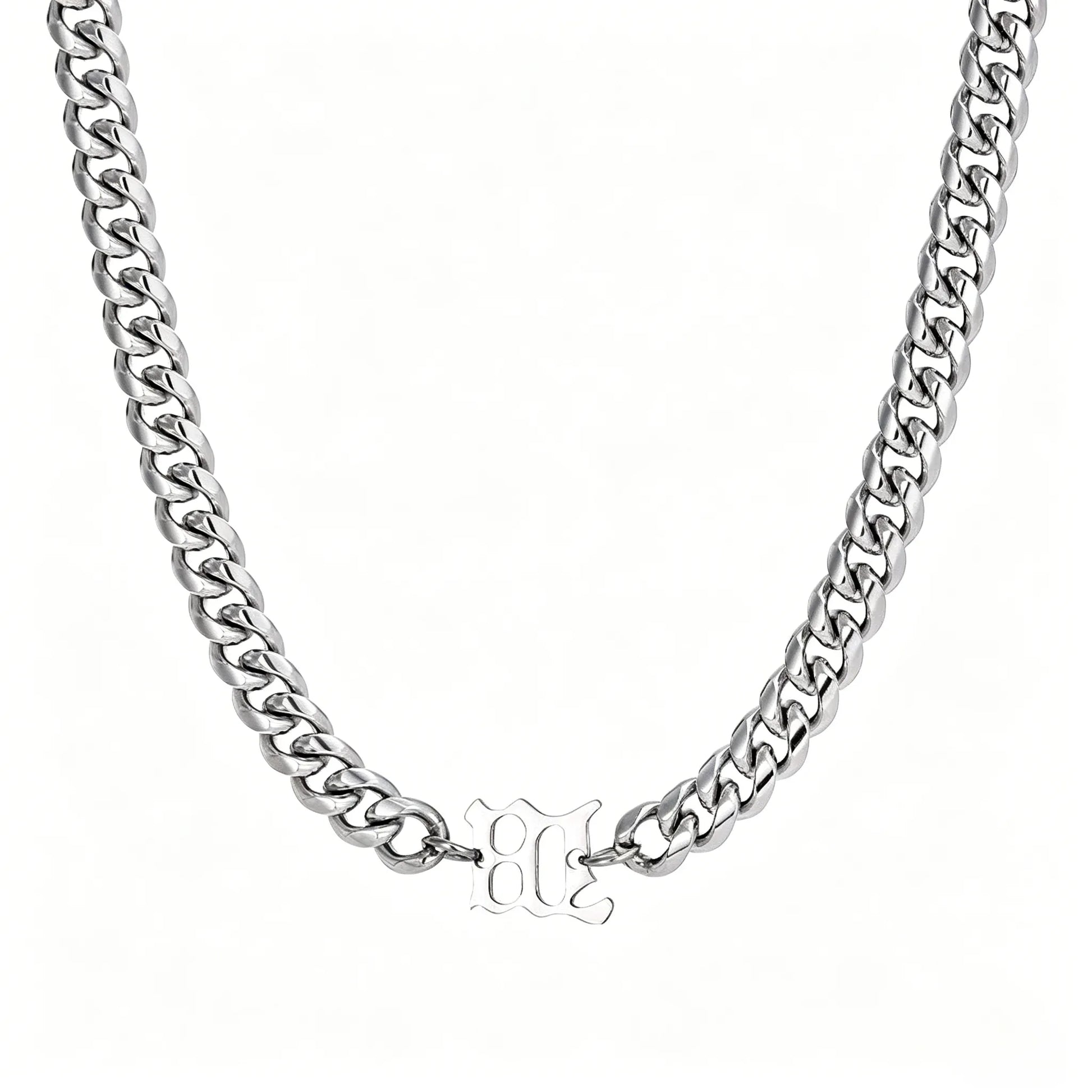 Silver stainless steel Cuban link necklace with gothic letter center charm on a white background.