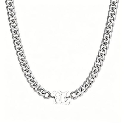 Silver stainless steel Cuban link necklace with gothic letter center charm on a white background.