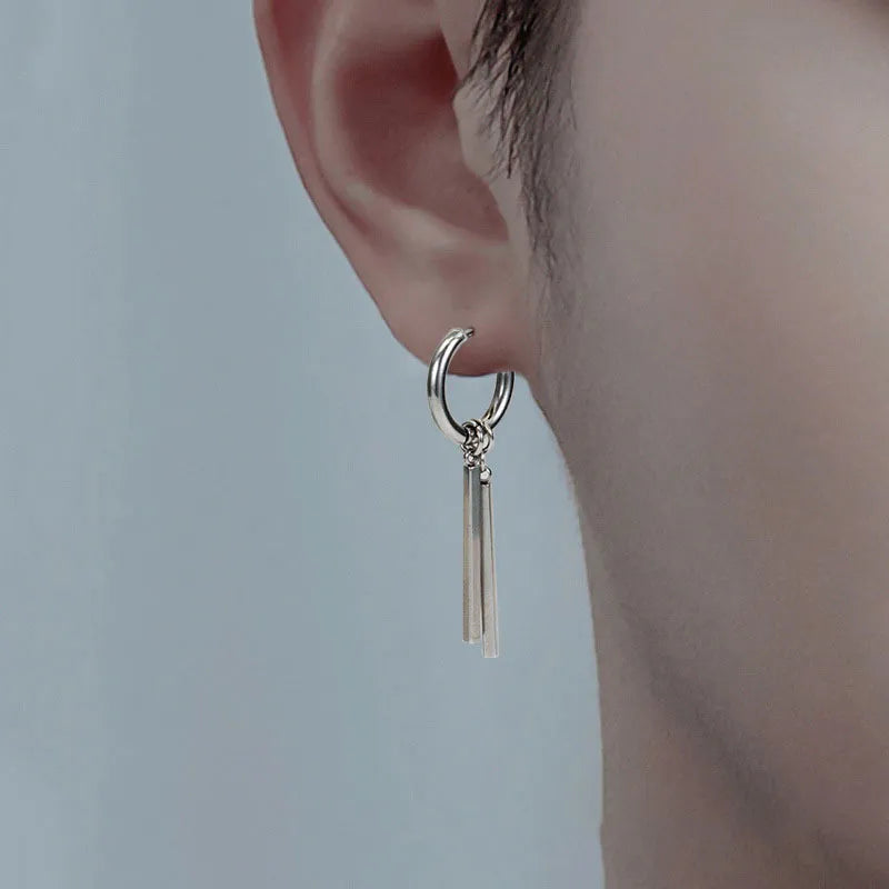 Close-up of a model wearing an edgy stainless steel bar dangle hoop earring.
